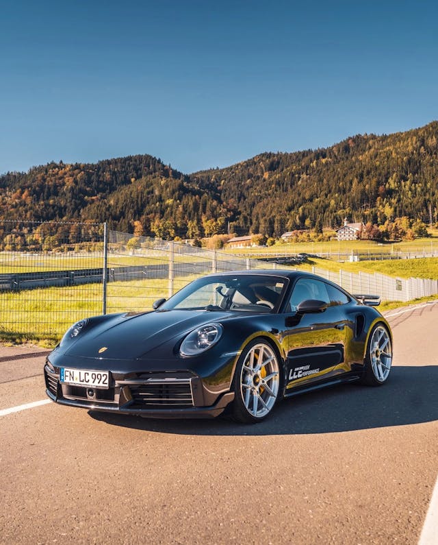 porche on a road with green forest background and blue sky
